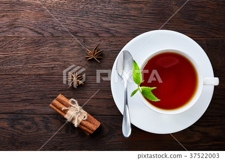 Overhead view of a cup of tea with cinnamom, mint 37522003
