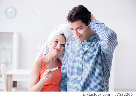 Wife and husband looking at pregnancy test 37522206