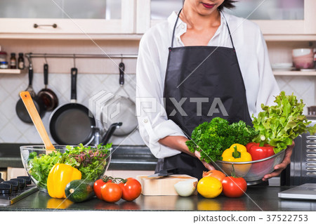 Young happiness Woman Cooking vegetables salad in the kitchen, H Young happiness Woman Cooking vegetables salad in the kitchen, H 37522753