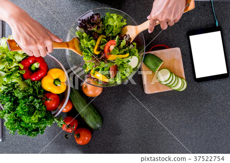 Young happiness Woman Cooking vegetables salad in the kitchen, H 37522754