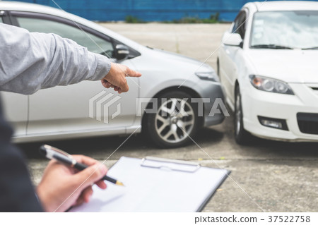 Insurance Agent examine Damaged Car and filing Report Claim Form 37522758