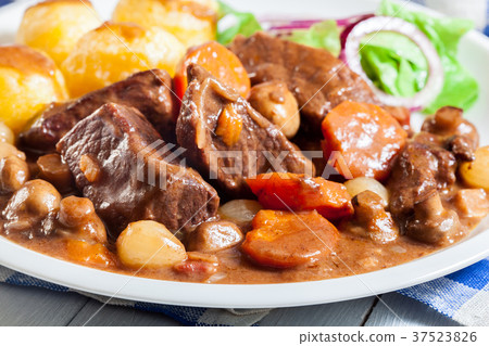 Beef Bourguignon stew served with baked potatoes Beef Bourguignon stew served with baked potatoes 37523826