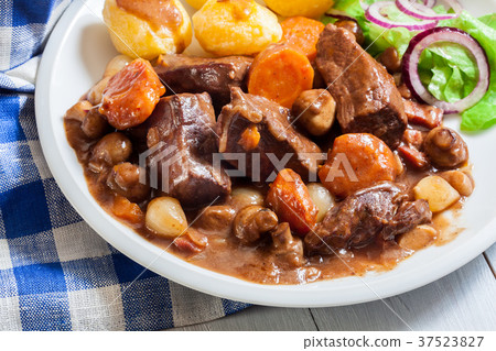 Beef Bourguignon stew served with baked potatoes Beef Bourguignon stew served with baked potatoes 37523827