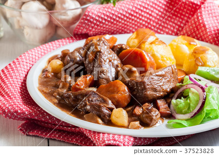 Beef Bourguignon stew served with baked potatoes Beef Bourguignon stew served with baked potatoes 37523828