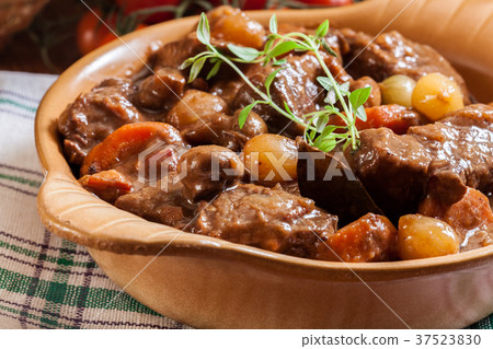Beef Bourguignon stew served with baguette 37523830