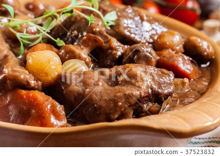 Beef Bourguignon stew served with baguette 37523832