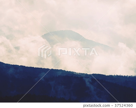 Mist in the mountains with peaks of hill, wet air Mist in the mountains with peaks of hill, wet air 37524360