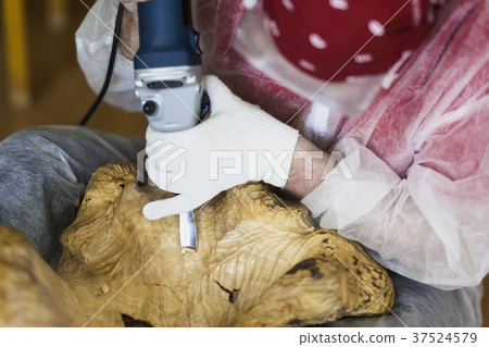 Woodcarver with glasses carving from natural 37524579