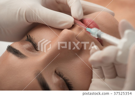 Surgeon holding syringe with collagen near woman Surgeon holding syringe with collagen near woman 37525354