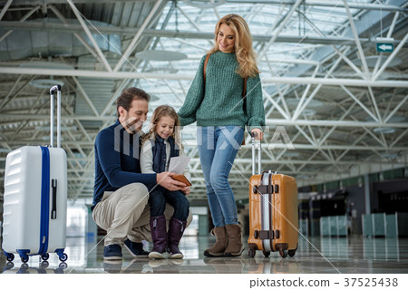 Joyful parents with her child checking tickets Joyful parents with her child checking tickets 37525438