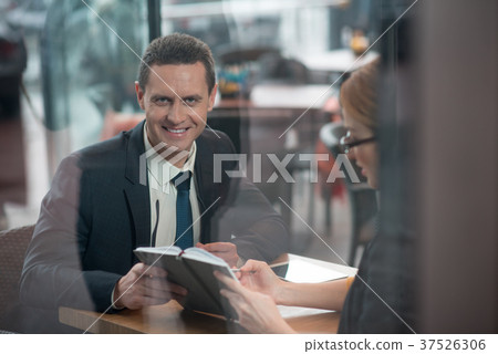 Cheerful male telling with partner in cafe 37526306