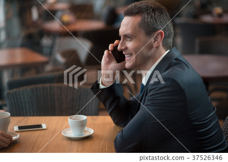 Happy male speaking by phone Happy male speaking by phone 37526346