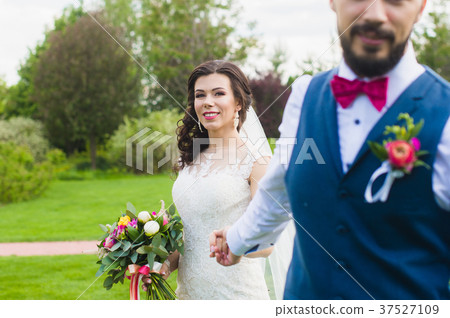 Groom holding hand of his smiling happy bride Groom holding hand of his smiling happy bride 37527109