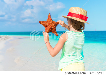 Adorable little girl with starfish on white empty 37527299