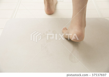 Woman feet using diatomaceous earth bath mat 37537697