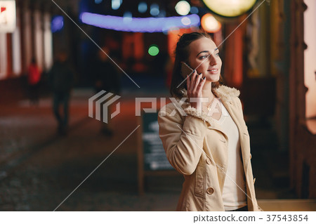 girl checking her phone outside at night 37543854