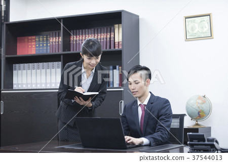 Young president and secretary meeting while looking at a personal computer Young president and secretary meeting while looking at a personal computer 37544013