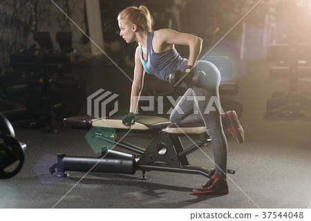 Young woman lifting the dumbbells 37544048