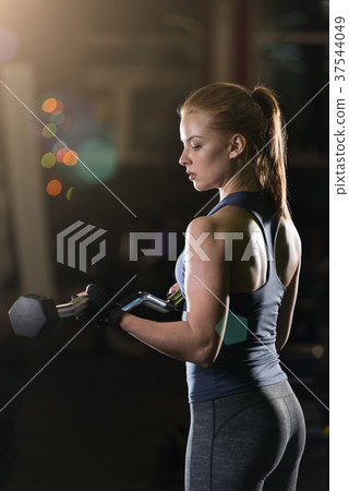 Young woman lifting the dumbbells 37544049