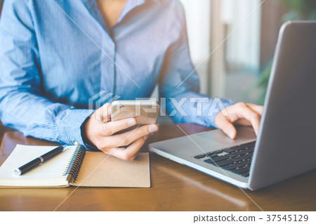 Business woman hand uses a mobile phone. 37545129