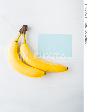 Two bananas on white with blue card Two bananas on white with blue card 37545801