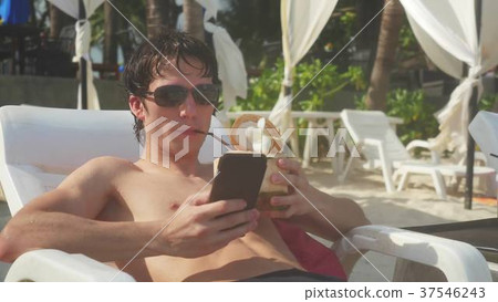 Young man wearing sunglasses using smartphone 37546243