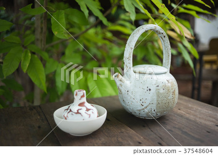 Clay pot of iced butterfly pea tea on wooden table 37548604