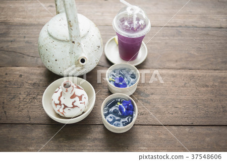 Clay pot of iced butterfly pea tea on wooden table 37548606