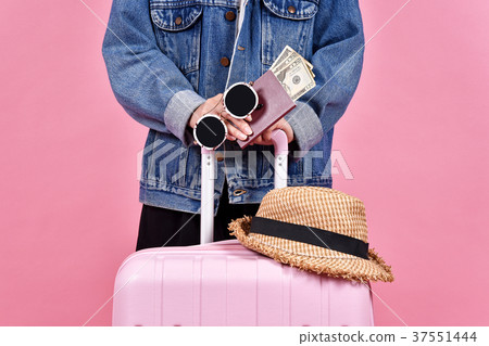 Traveler holding pink suitcase, Passenger passport 37551444