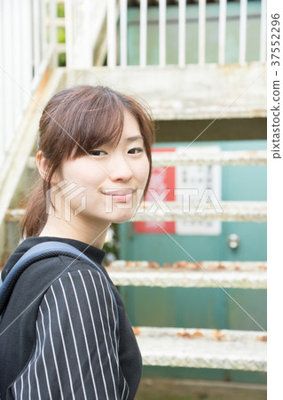 A woman standing in front of the stairs (Nihon Keizai University) A woman standing in front of the stairs (Nihon Keizai University) 37552296