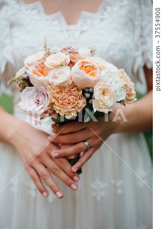 wedding bouquet in bride's hands. beige roses and wedding bouquet in bride's hands. beige roses and 37554908