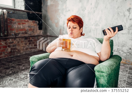 Overweight woman drinks beer, high calorie food Overweight woman drinks beer, high calorie food 37555252
