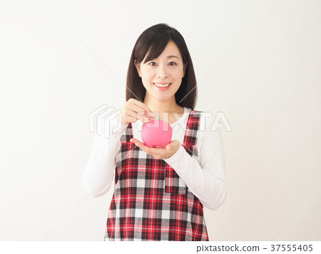 Woman putting coin in pink pig money box Woman putting coin in pink pig money box 37555405