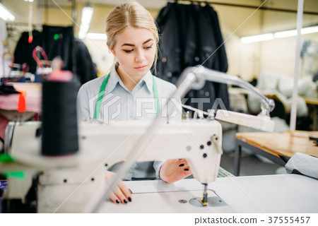 Dressmaker sews fabrics on a sewing machine 37555457