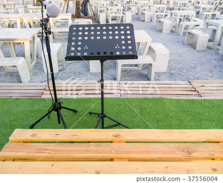 Microphone on the black stand. 37556004