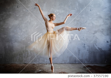 Young ballerina in golden costume posing in studio 37557190