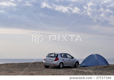Car and a tent against the background of the sea. Car and a tent against the background of the sea. 37557380