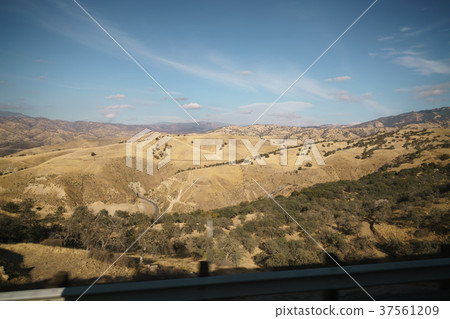 Golden hills with trees and roads in clear day Golden hills with trees and roads in clear day 37561209