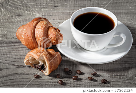 Coffee and croissants on a wooden table Coffee and croissants on a wooden table 37562124