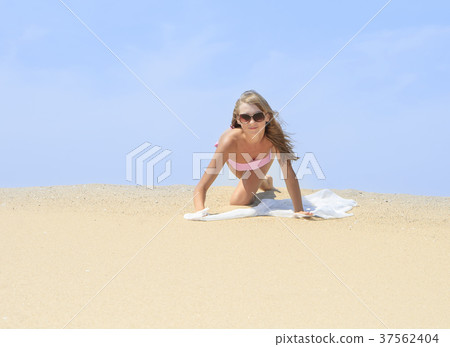 Tanned young female relaxing on the beach Tanned young female relaxing on the beach 37562404