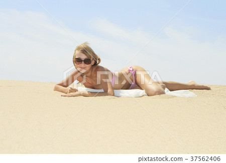 Tanned young female relaxing on the beach Tanned young female relaxing on the beach 37562406