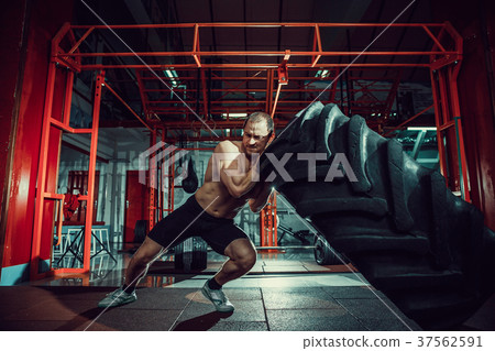 Shirtless man flipping heavy tire Shirtless man flipping heavy tire 37562591