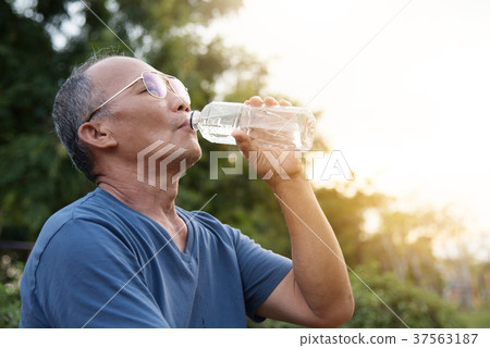 Asian senior male drinking water. 37563187