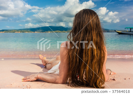 Young woman with long brown hair daydreaming while Young woman with long brown hair daydreaming while 37564018