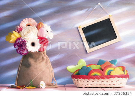 Diverse flowers and a basket with cookies Diverse flowers and a basket with cookies 37566334