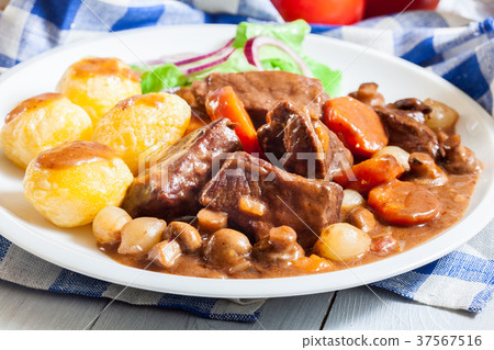 Beef Bourguignon stew served with baked potatoes Beef Bourguignon stew served with baked potatoes 37567516