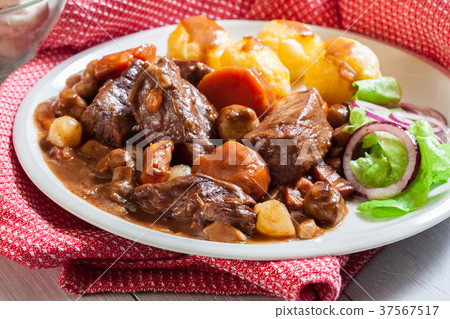Beef Bourguignon stew served with baked potatoes Beef Bourguignon stew served with baked potatoes 37567517