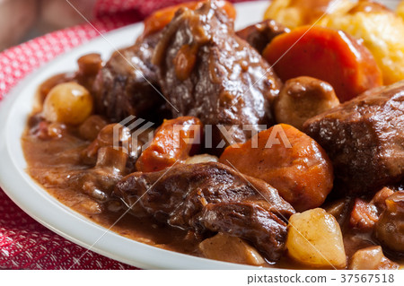 Beef Bourguignon stew served with baked potatoes Beef Bourguignon stew served with baked potatoes 37567518