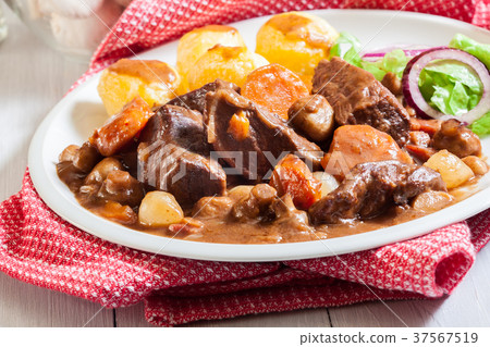 Beef Bourguignon stew served with baked potatoes 37567519
