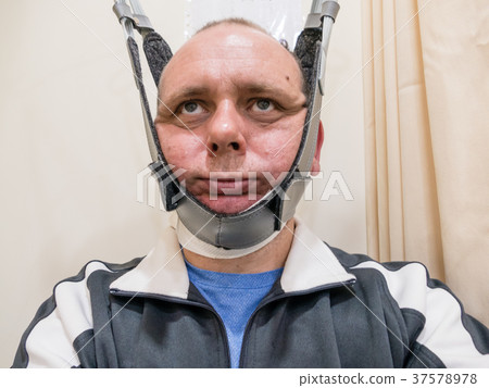 Man in neck traction machine 37578978